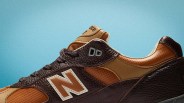 Close-up of a brown and tan New Balance sneaker with textured leather and mesh panels against a blue background.