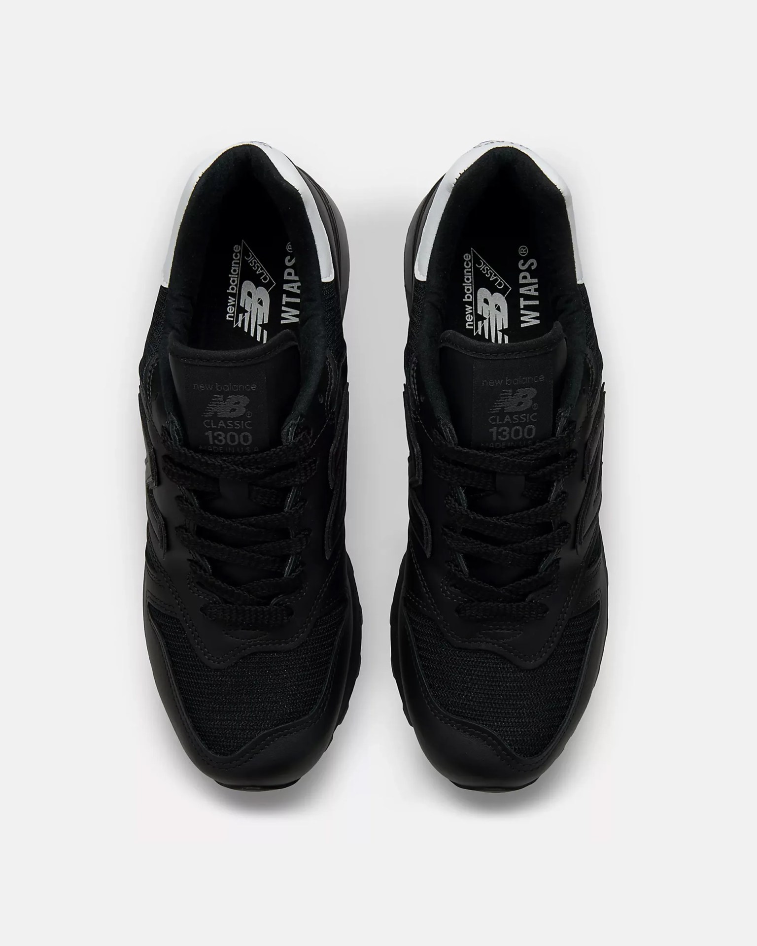 Pair of black New Balance Classic 1300 sneakers with mesh and leather uppers, viewed from above.