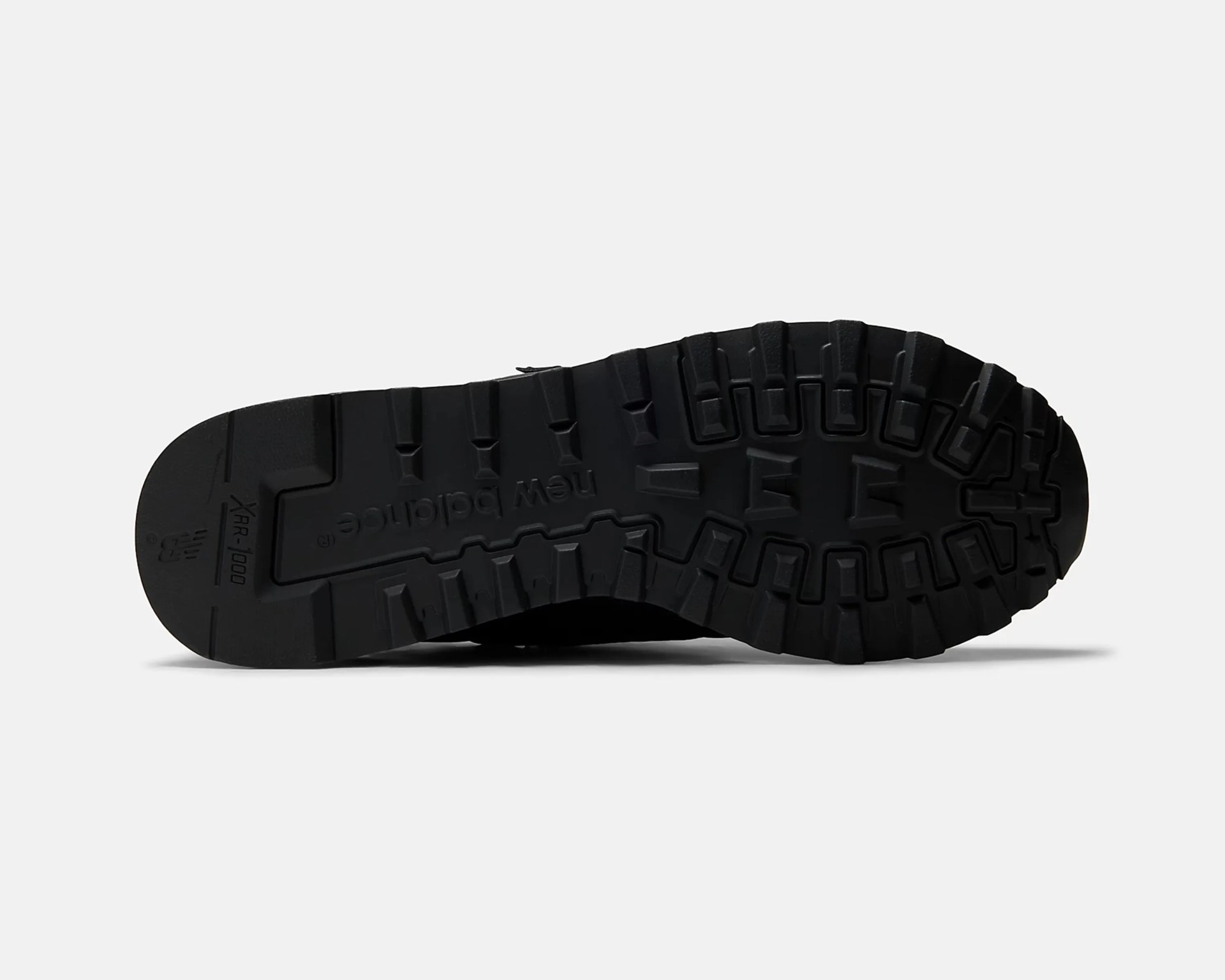 Black rubber outsole of a New Balance shoe with deep treads and "XR-1000" branding.