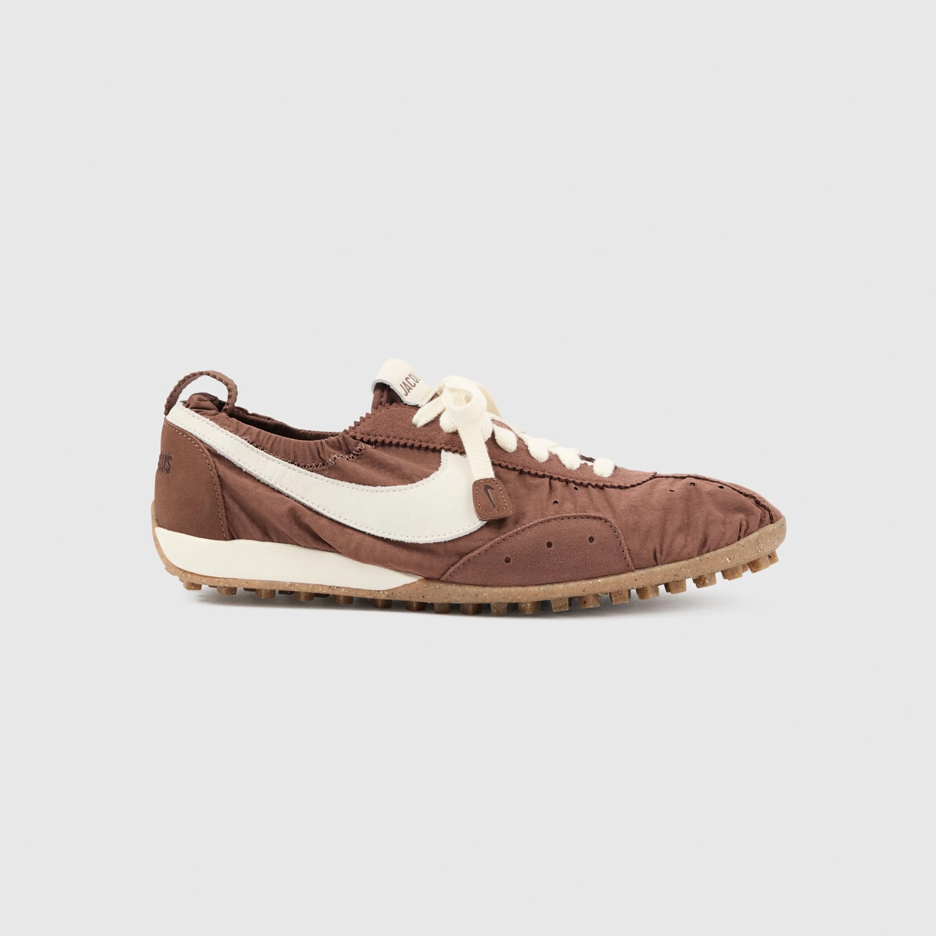 Brown and white low-top sneaker with textured sole and white laces on a light gray background.