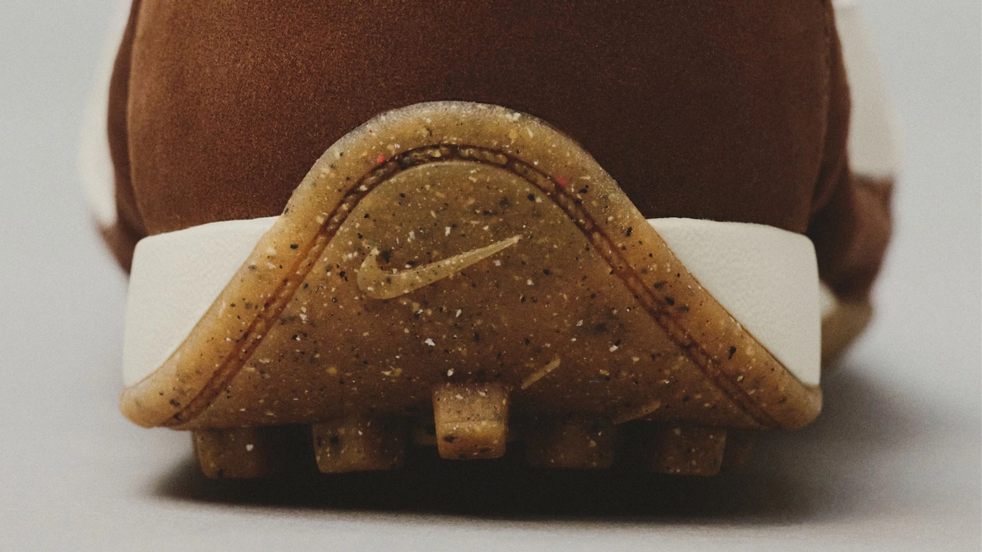 Close-up of the speckled brown Nike cleat sole with a white midsole and brown upper.