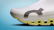 Close-up of a white sneaker toe with a black logo, yellow midsole, and purple outsole on a blue background.