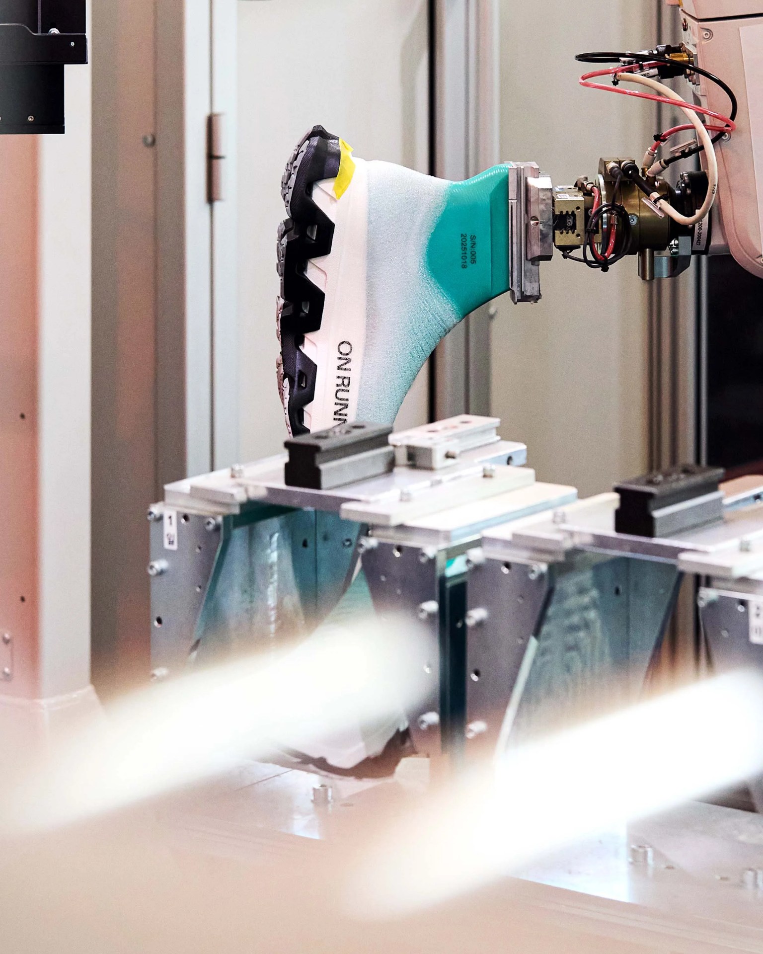 White and teal sock-style sneaker with black sole labeled 