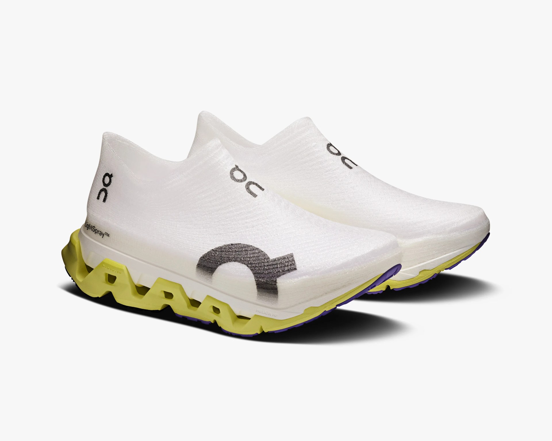 Pair of white slip-on running shoes with black logos and yellow zigzag soles on a white background.
