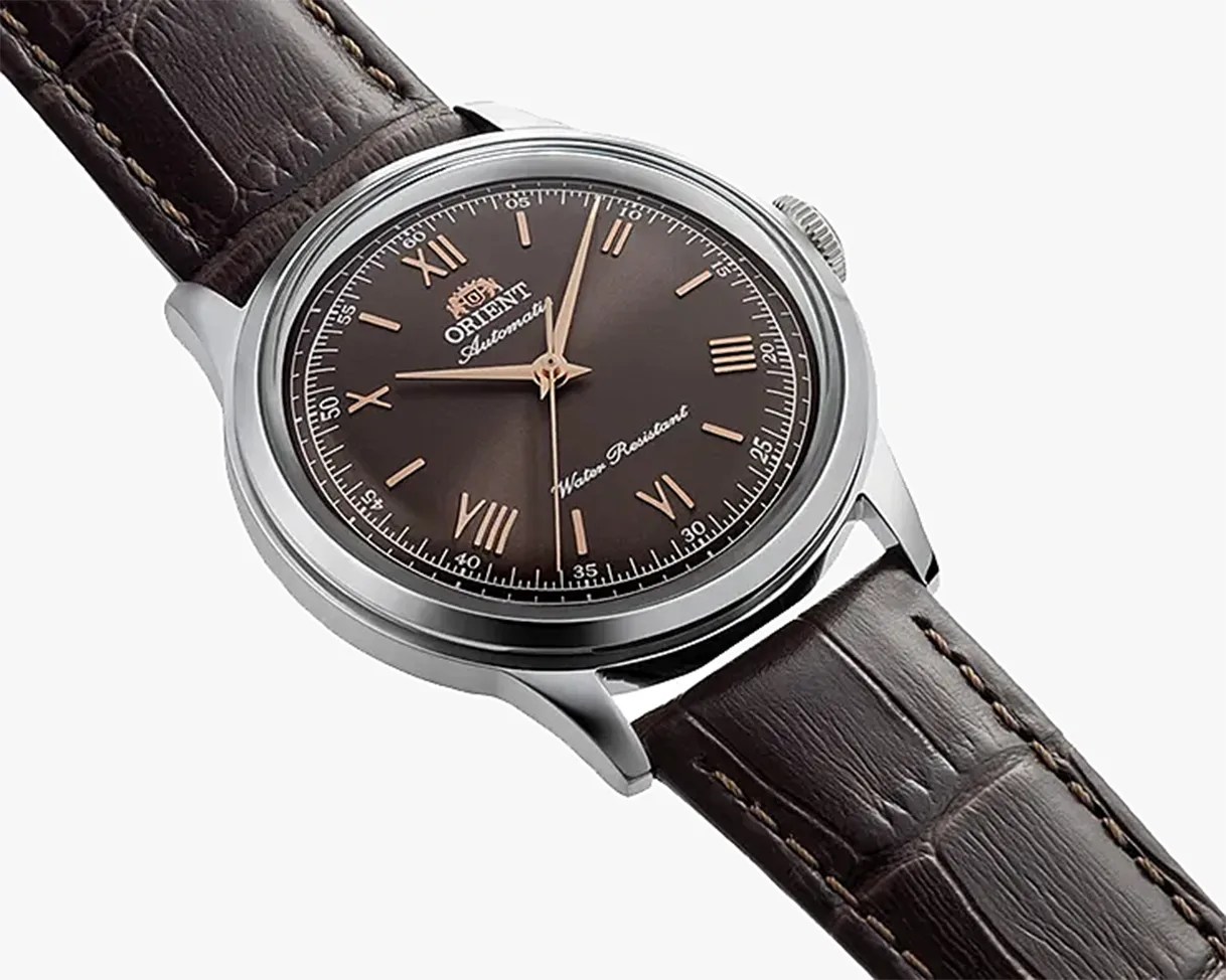 Silver Orient wristwatch with brown sunburst dial, rose gold Roman numerals, and dark brown leather strap.