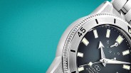 Close-up of a silver diver's watch with a black dial, luminous markers, and a rotating bezel showing "45".