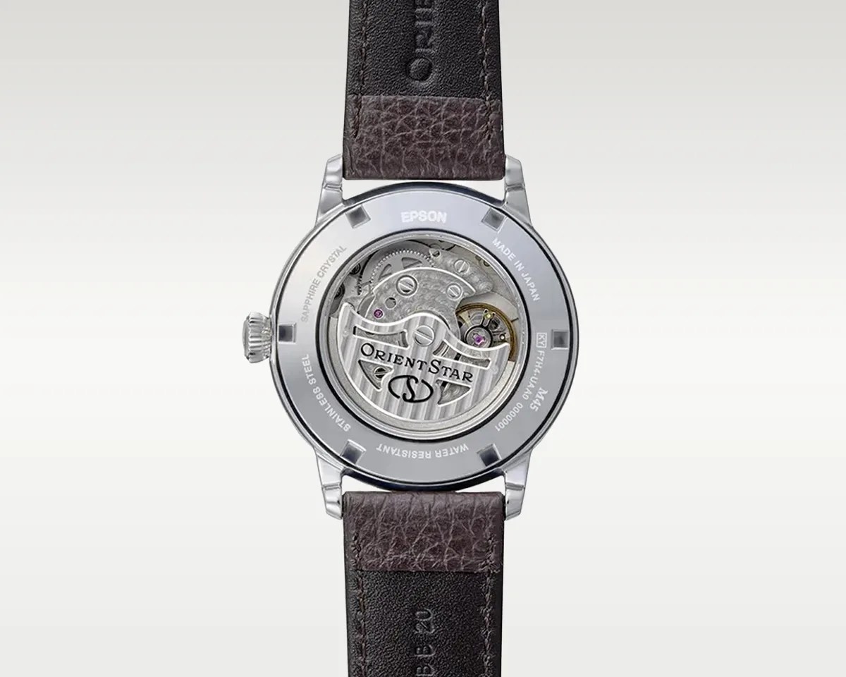 Back view of an Orient Star wristwatch with visible mechanical movement and brown leather strap.