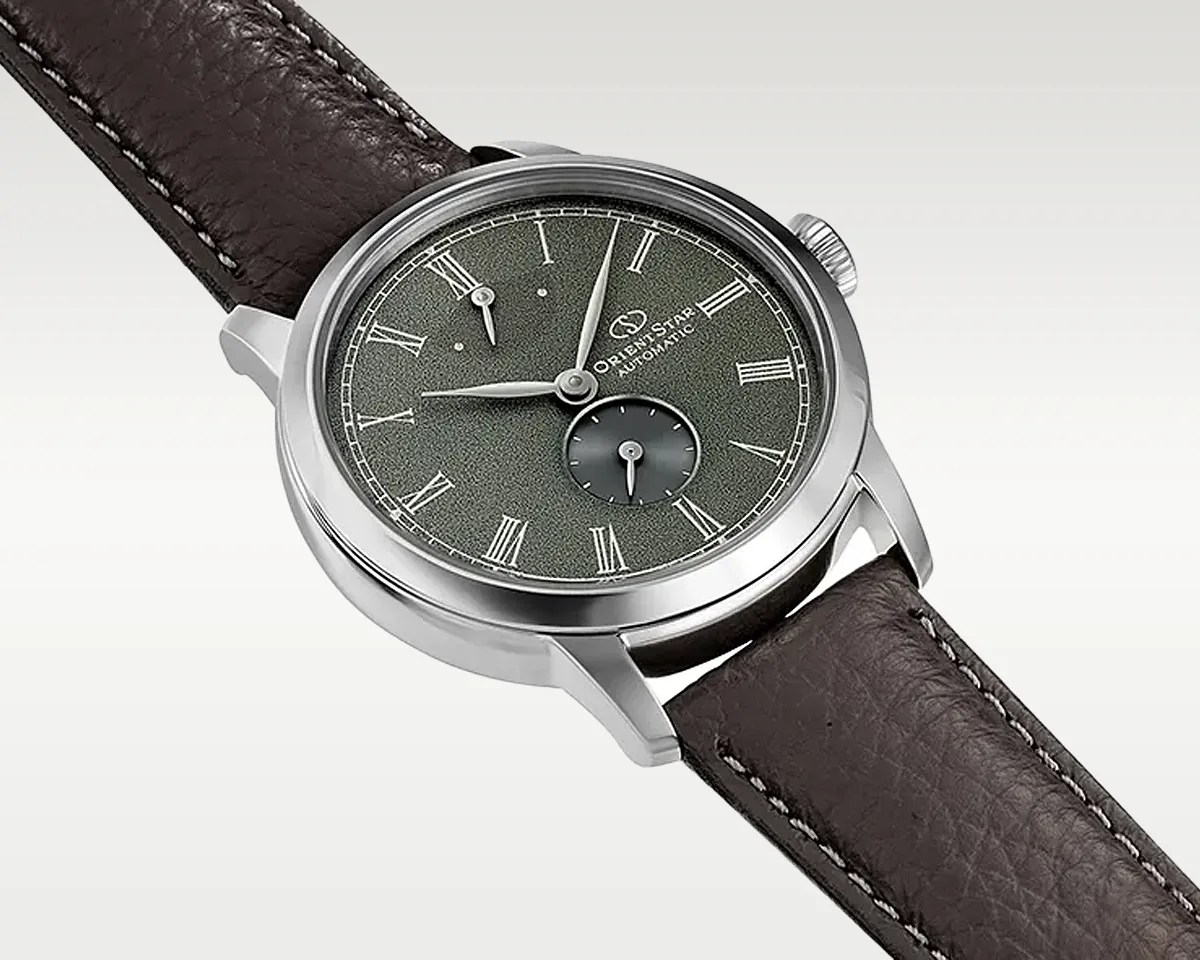 Silver Orient Star automatic watch with textured green dial, Roman numerals, subdial, and dark brown leather strap.