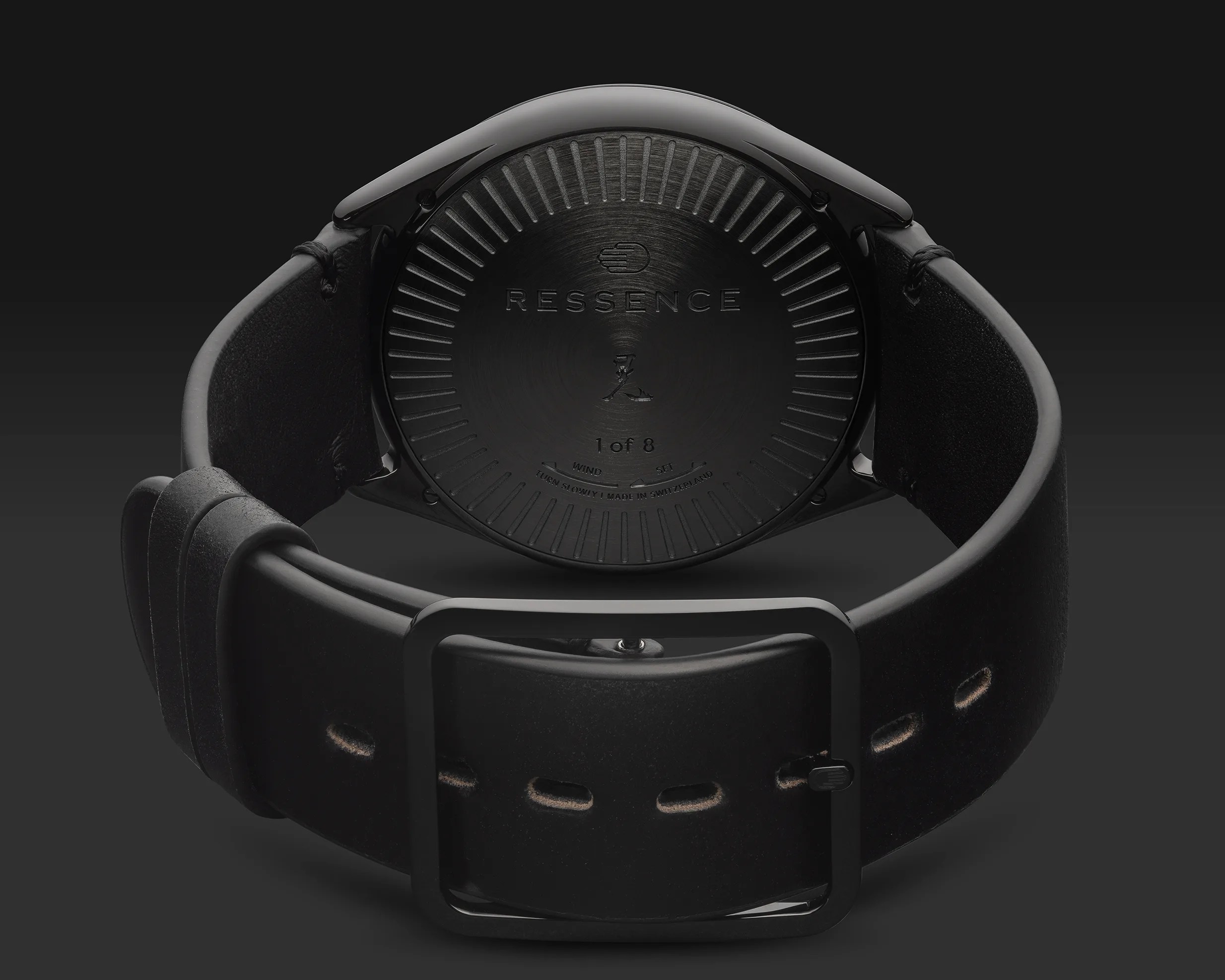 Back view of a black Ressence wristwatch with a black leather strap and a matte black buckle.