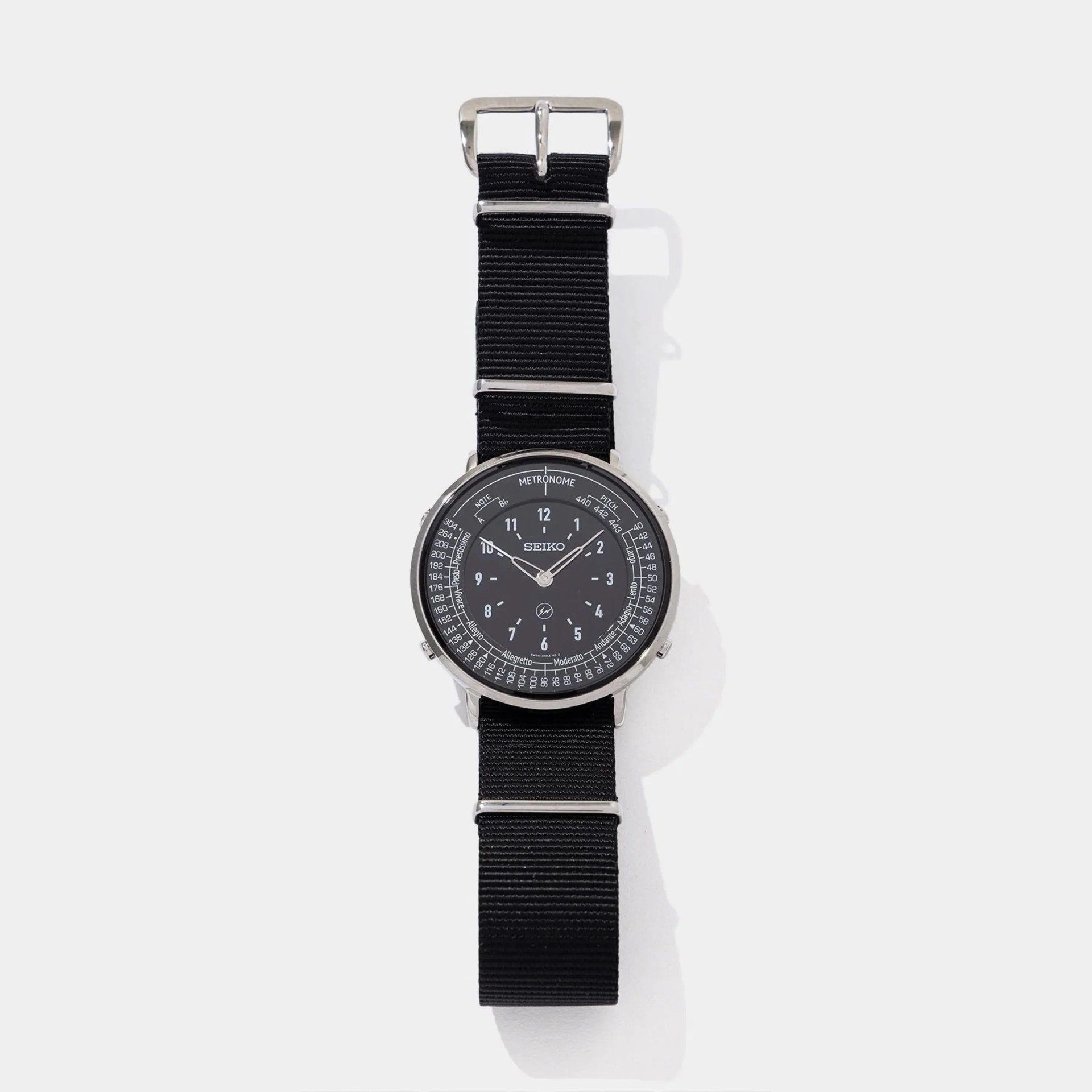 Black Seiko wristwatch with a round dial featuring metronome and pitch markings, and a black fabric strap.