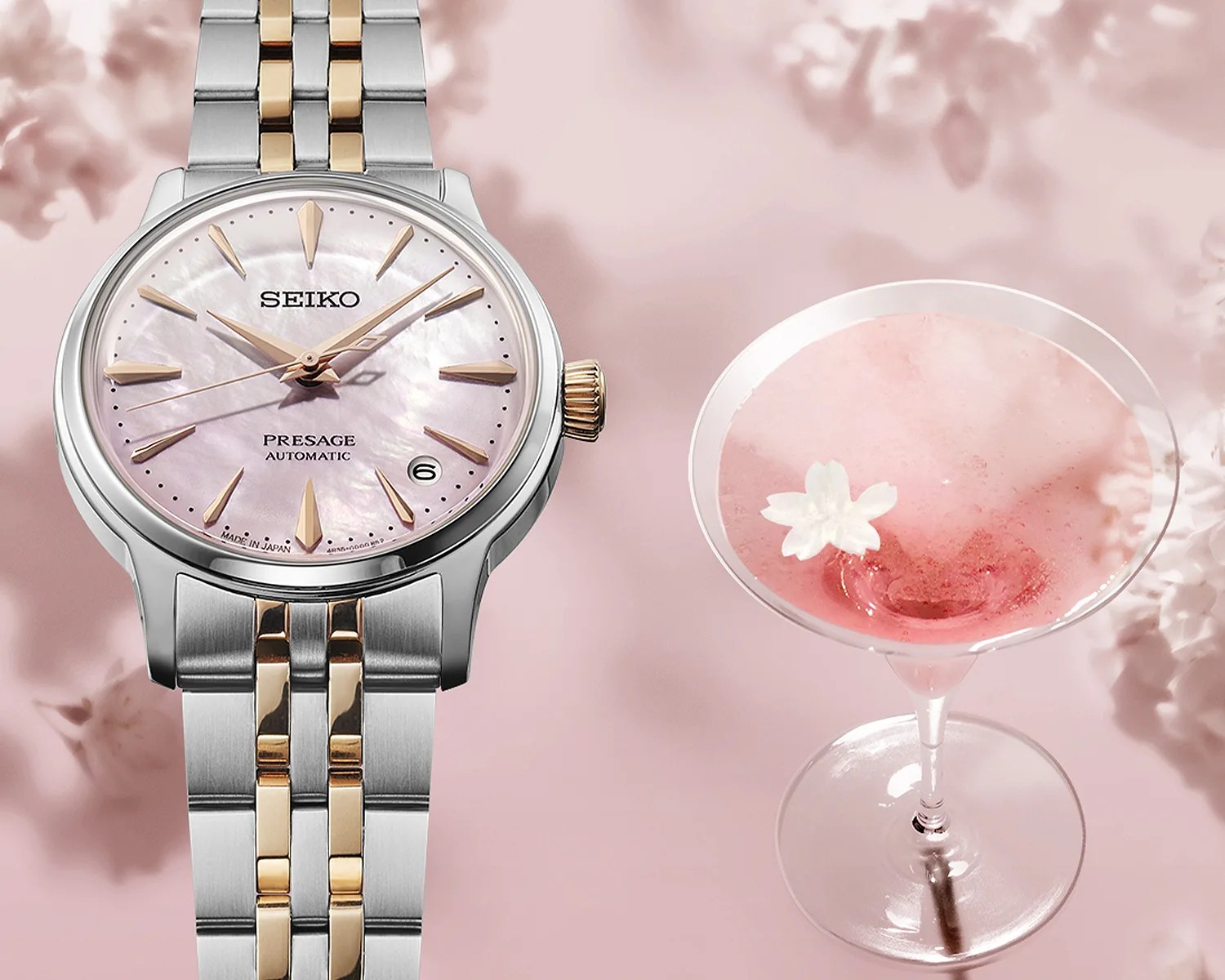 Two-tone silver and gold Seiko Presage automatic watch with a pink mother-of-pearl dial next to a pink cocktail in a martini glass.