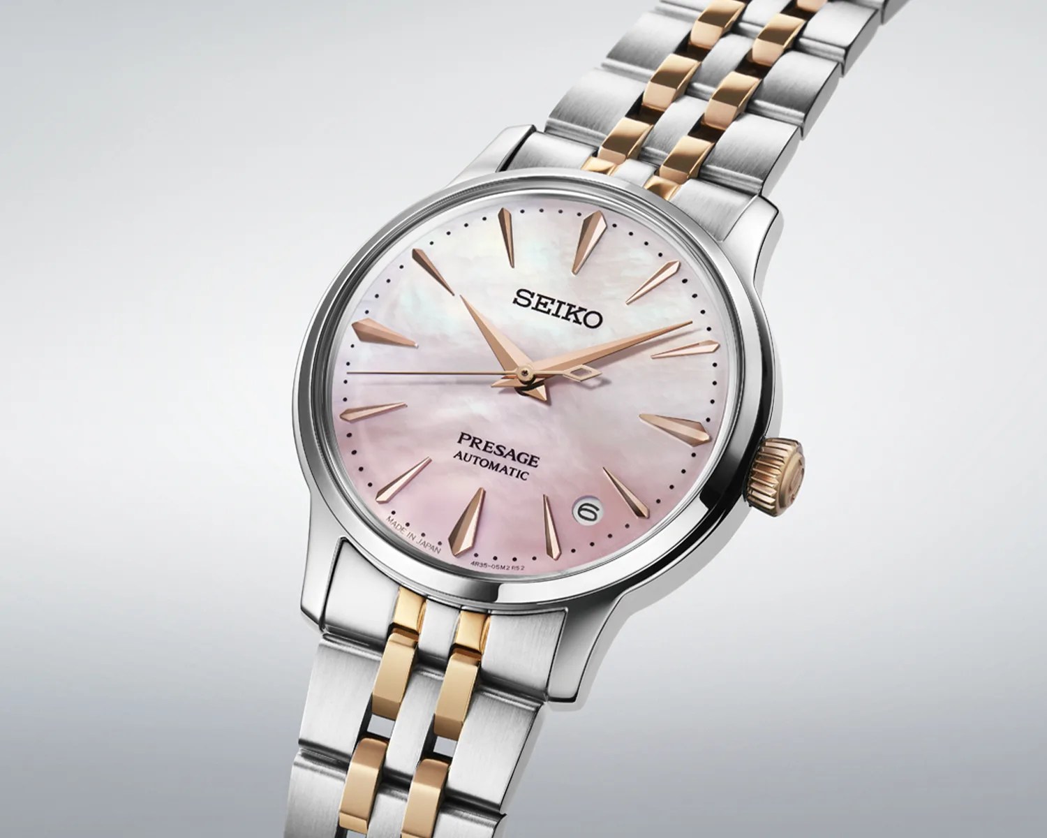Seiko Presage automatic wristwatch with a pink mother-of-pearl dial and two-tone silver and gold metal bracelet.