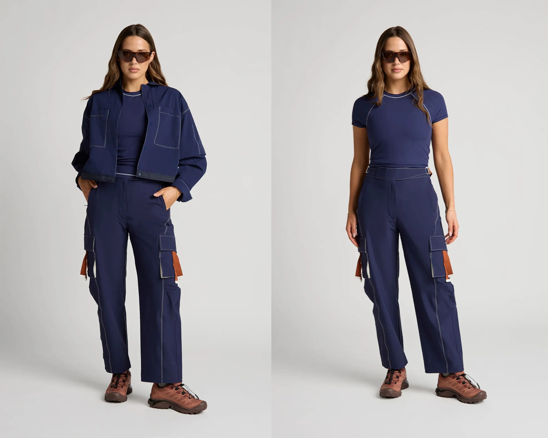 Woman wearing navy blue cargo pants with large side pockets, brown hiking shoes, and tortoiseshell sunglasses, shown with and without a matching navy cropped jacket.