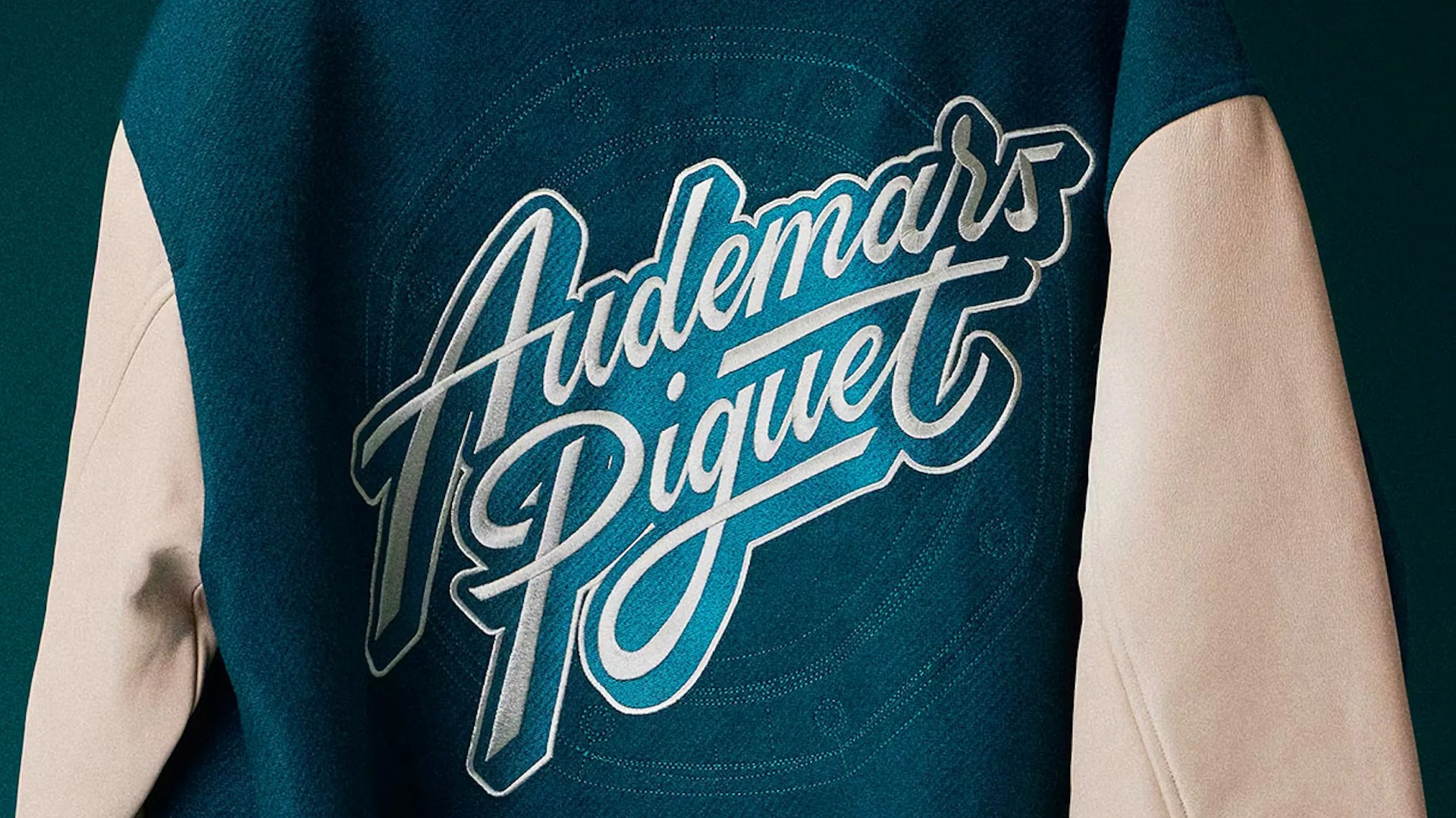 Teal and beige jacket with large "Audemars Piguet" script logo on the back.