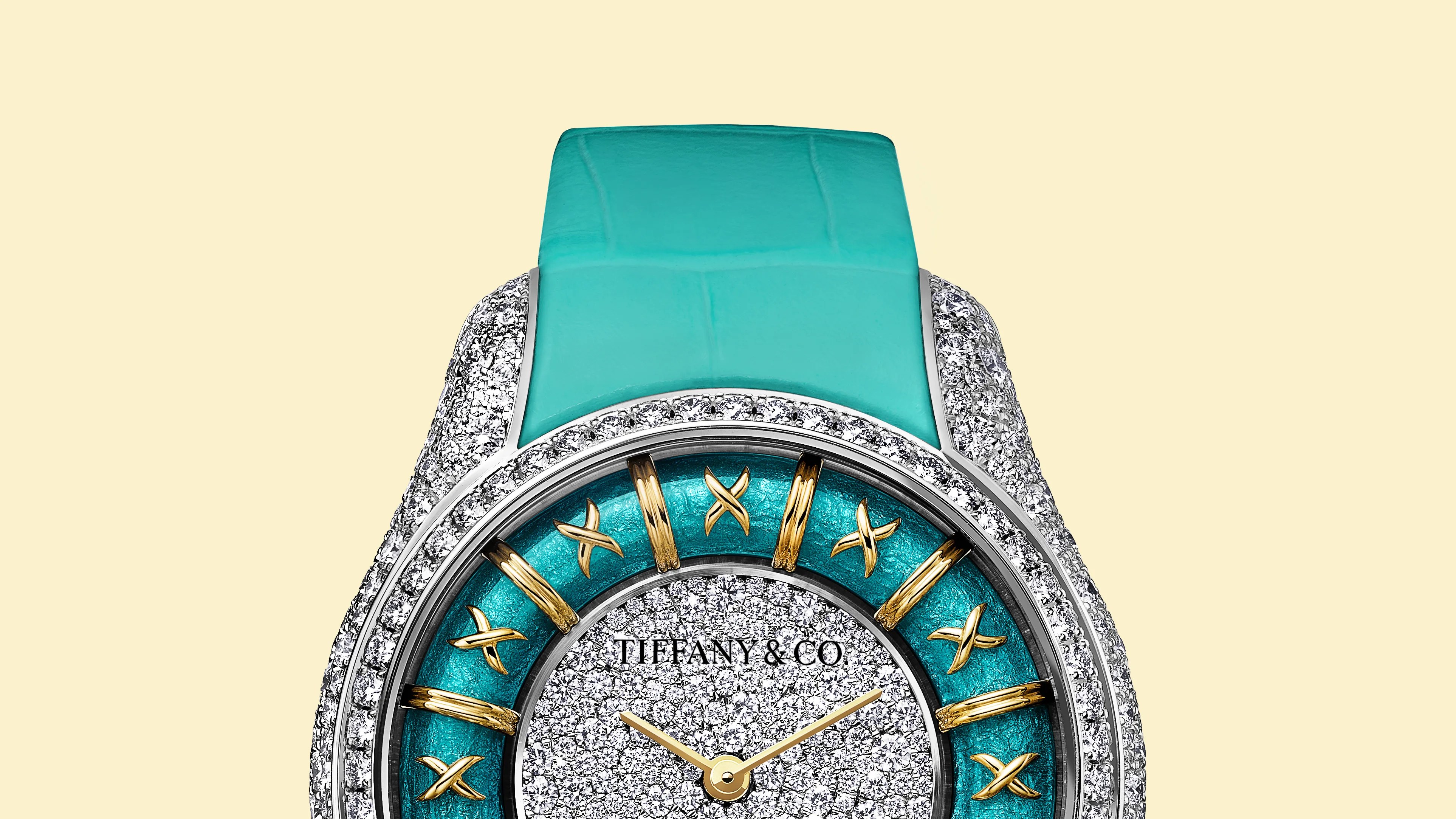 Tiffany & Co. watch with turquoise leather strap, diamond-encrusted bezel, and gold Roman numeral markers on a turquoise dial.