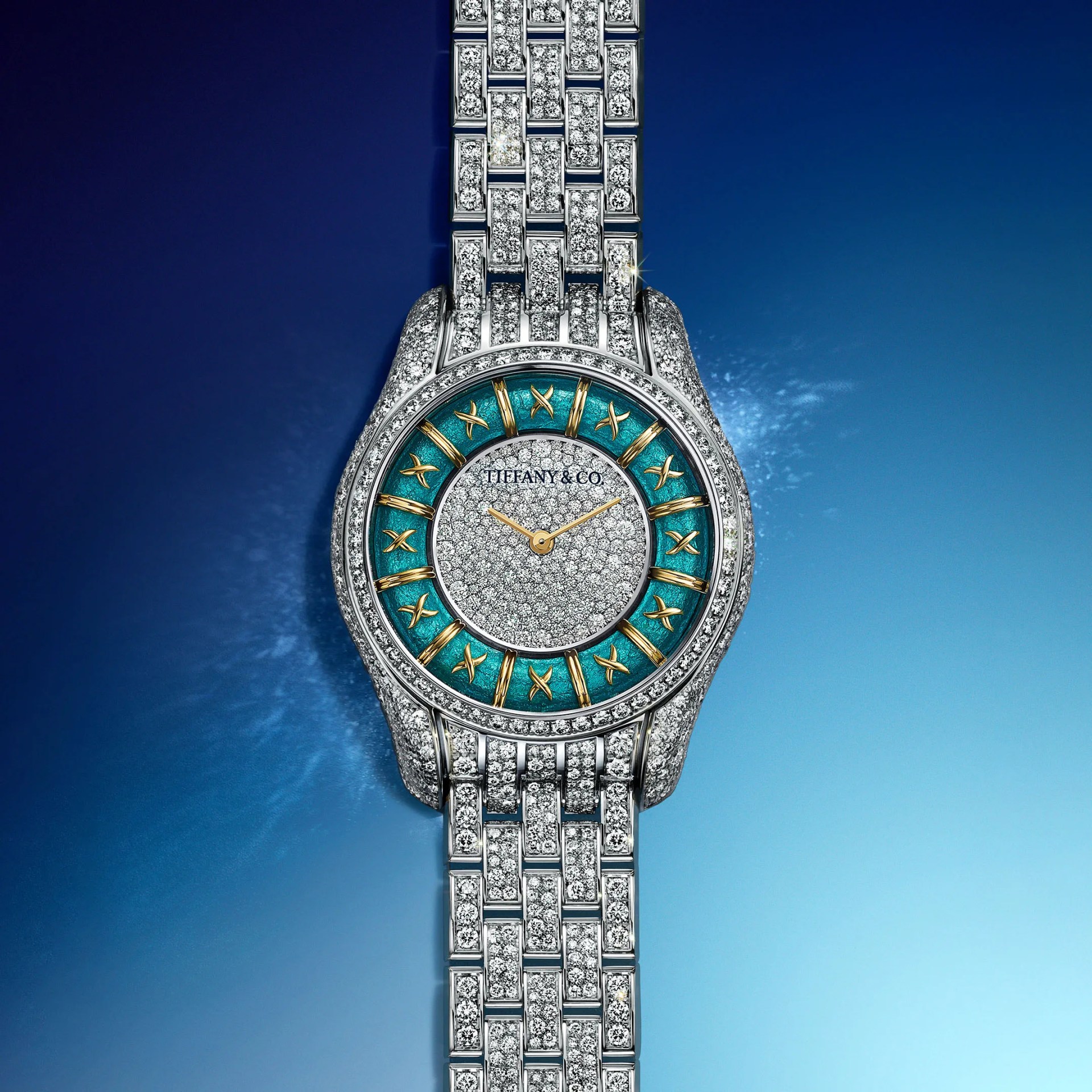 Silver and diamond-encrusted Tiffany & Co. wristwatch with turquoise and gold Roman numeral dial on a blue gradient background.