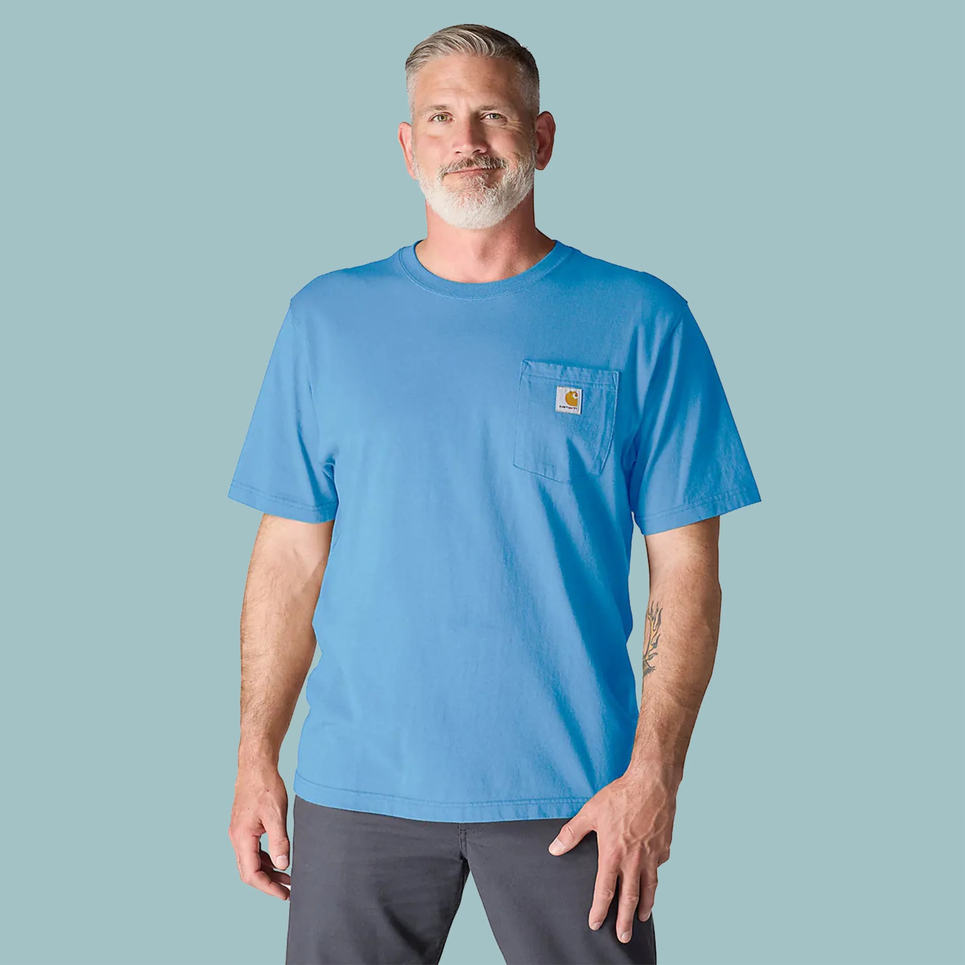 Light blue short-sleeve Carhartt pocket t-shirt worn by a man with gray hair and beard.