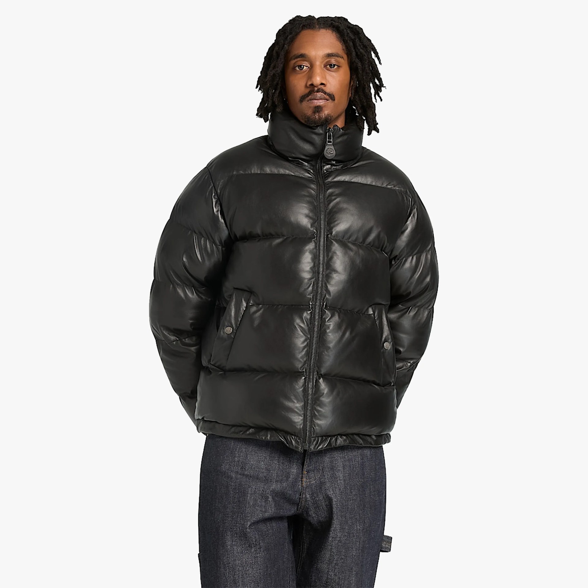 Black shiny puffer jacket with high collar and front zipper worn by a person.