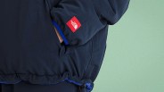 Close-up of a navy blue The North Face jacket sleeve with a red logo patch and elastic cuff.