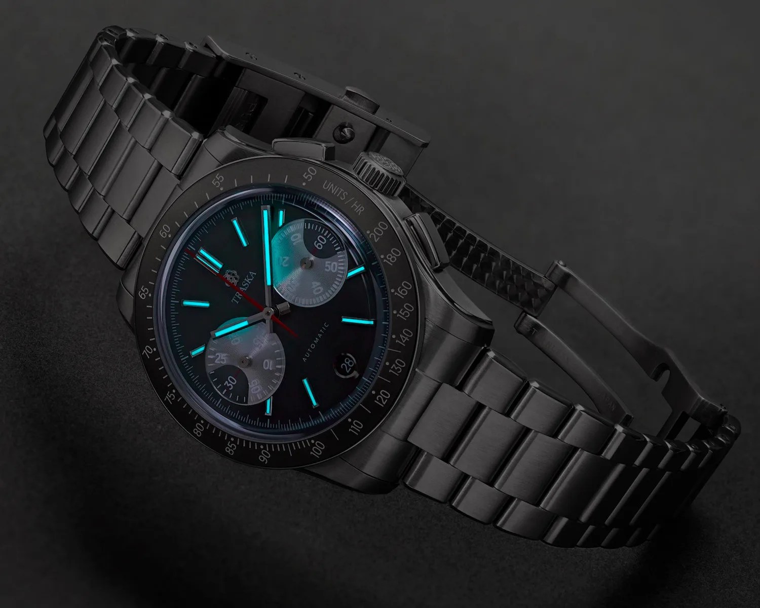 Black stainless steel wristwatch with luminous blue hour markers and two silver subdials on a dark surface.
