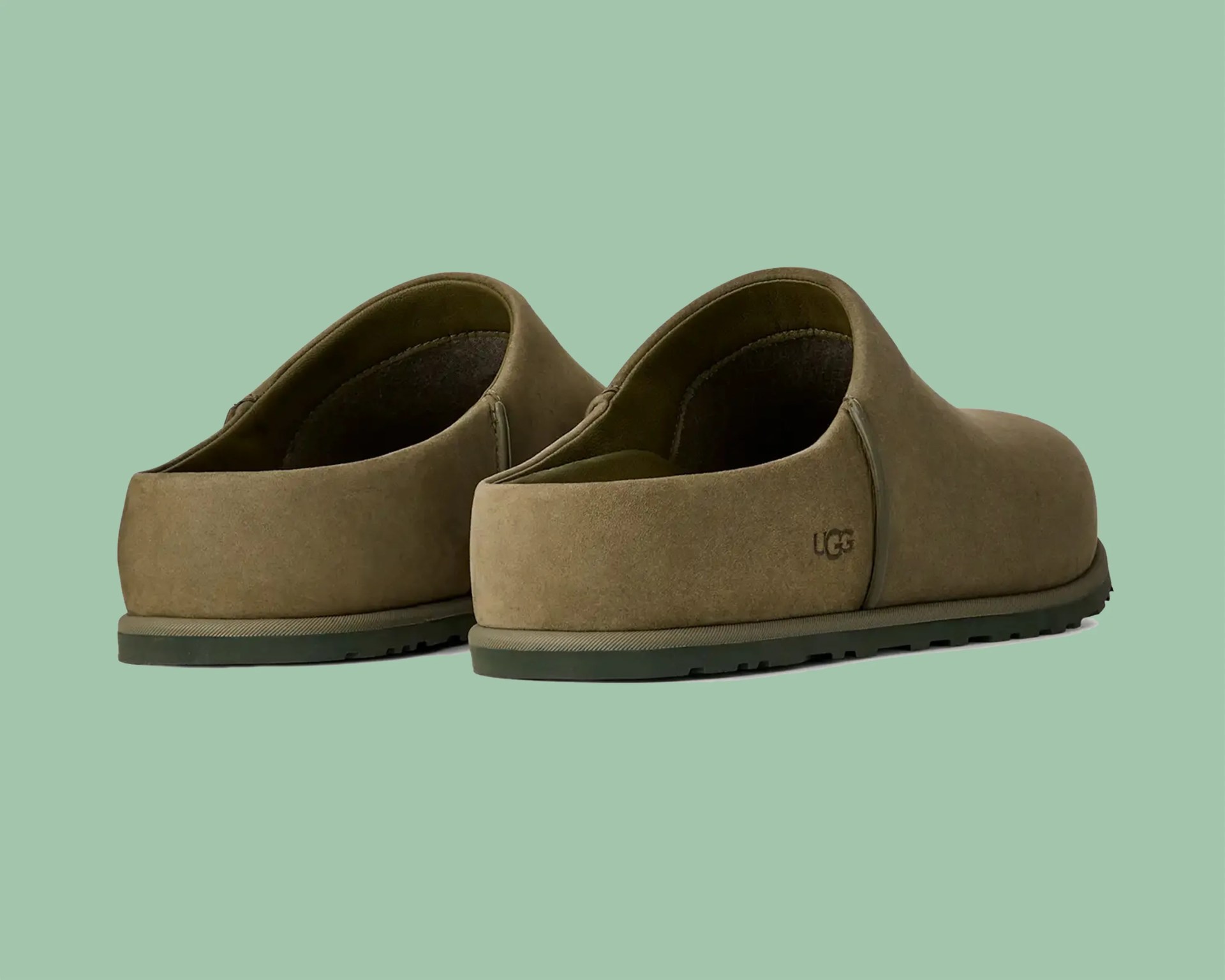 Pair of olive green suede slip-on shoes with UGG logo on the heel and rubber soles.