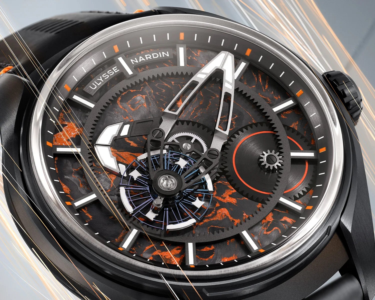 Close-up of a Ulysse Nardin watch face with black and orange textured dial, visible gears, and silver hands.