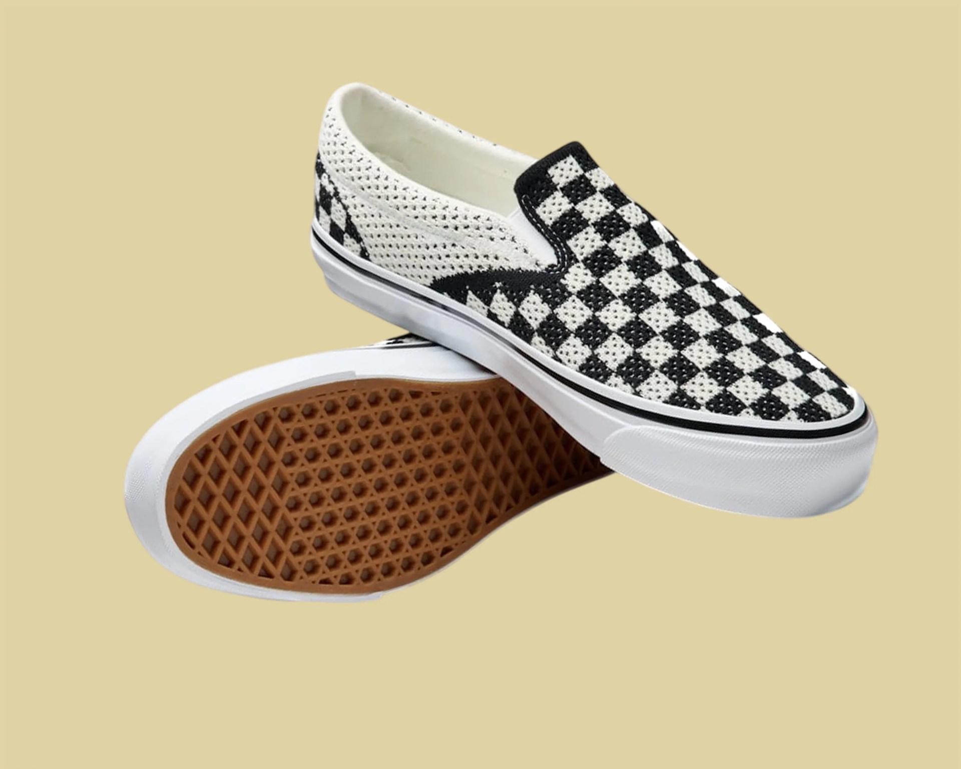 Black and white checkered slip-on sneakers with white rubber soles and brown waffle-patterned outsoles.