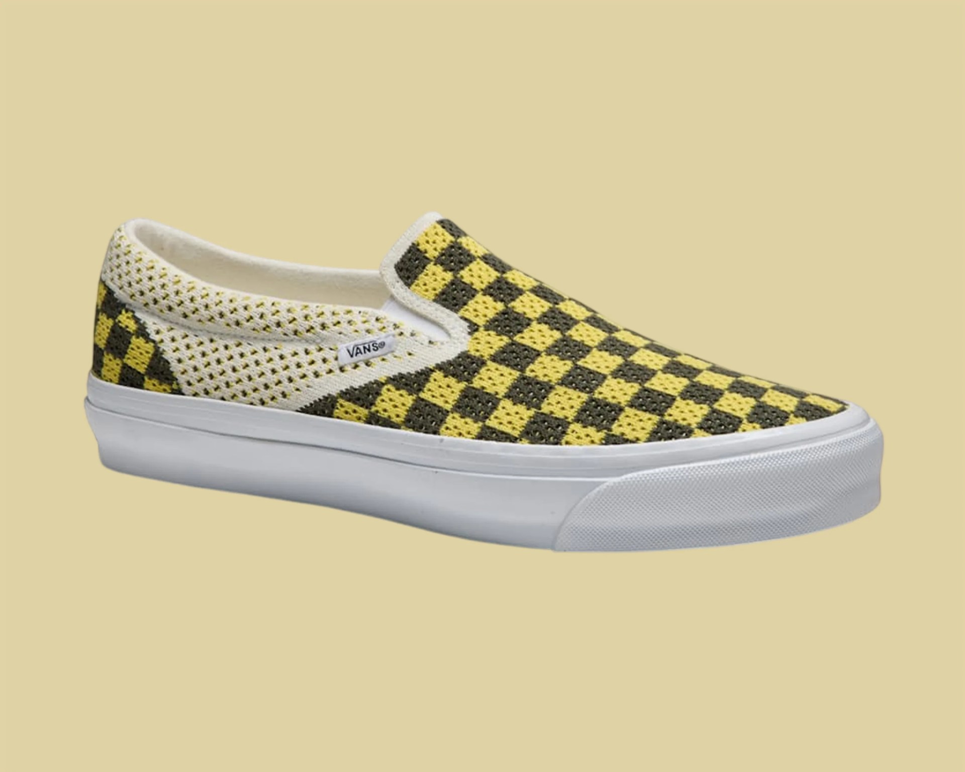 Yellow and black checkered slip-on Vans sneaker with white sole on beige background.
