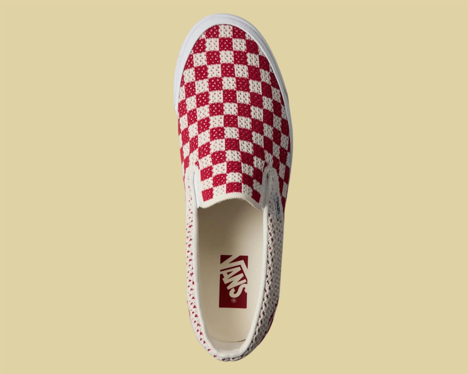 Red and white checkered Vans slip-on shoe with a white sole viewed from above.