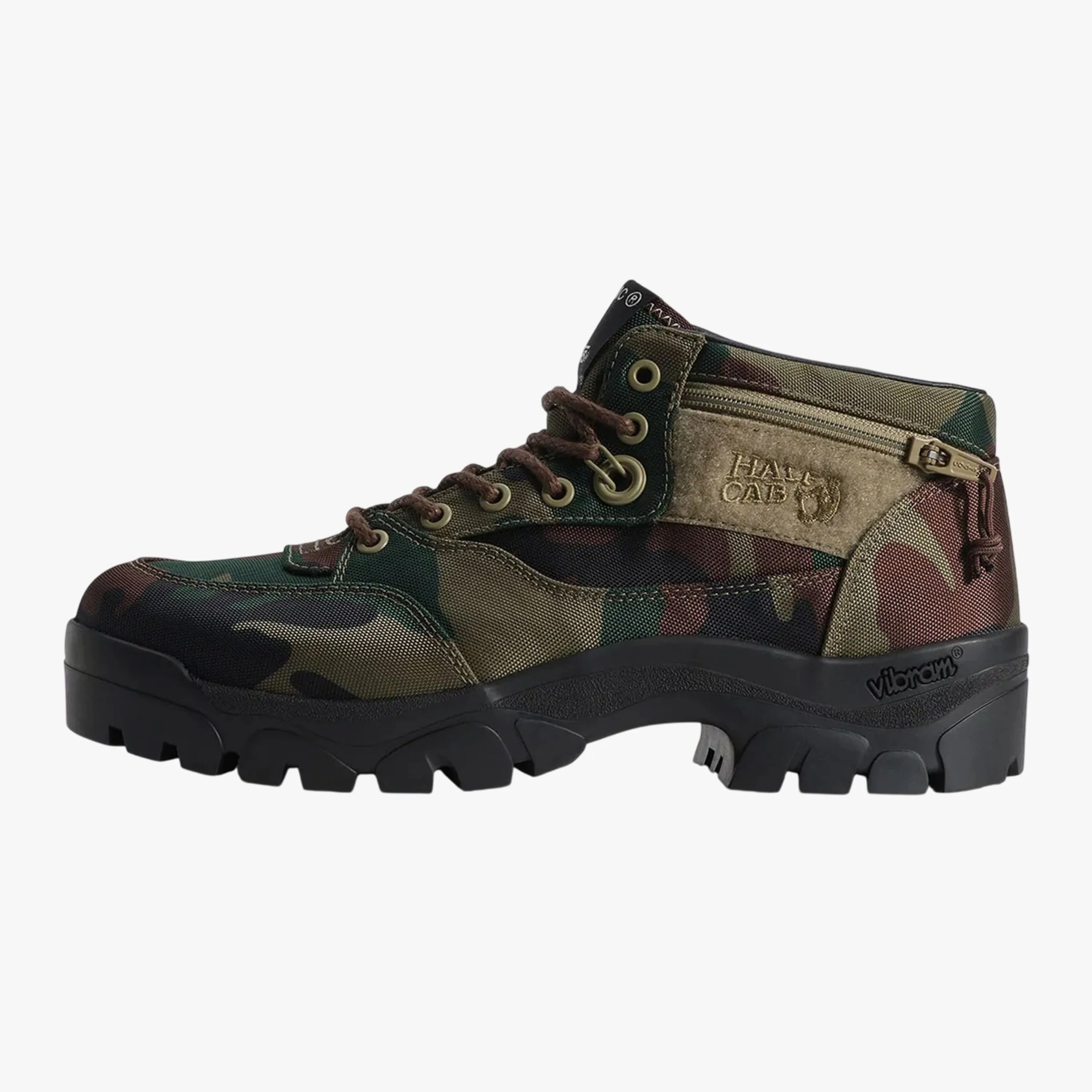 Camouflage-patterned ankle boot with brown laces, zipper pocket, and black Vibram sole.