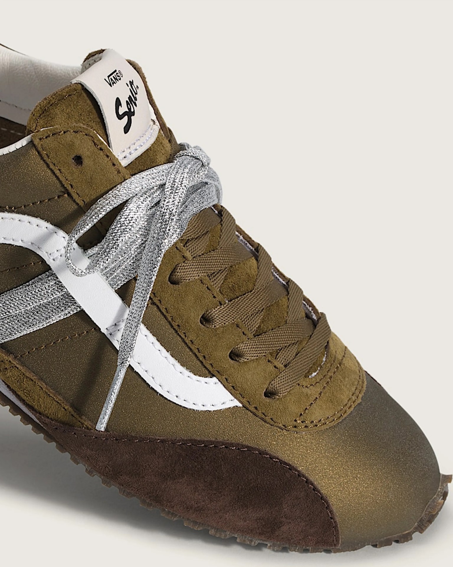 Brown and dark brown Vans sneaker with white side stripe and mixed brown and silver laces.