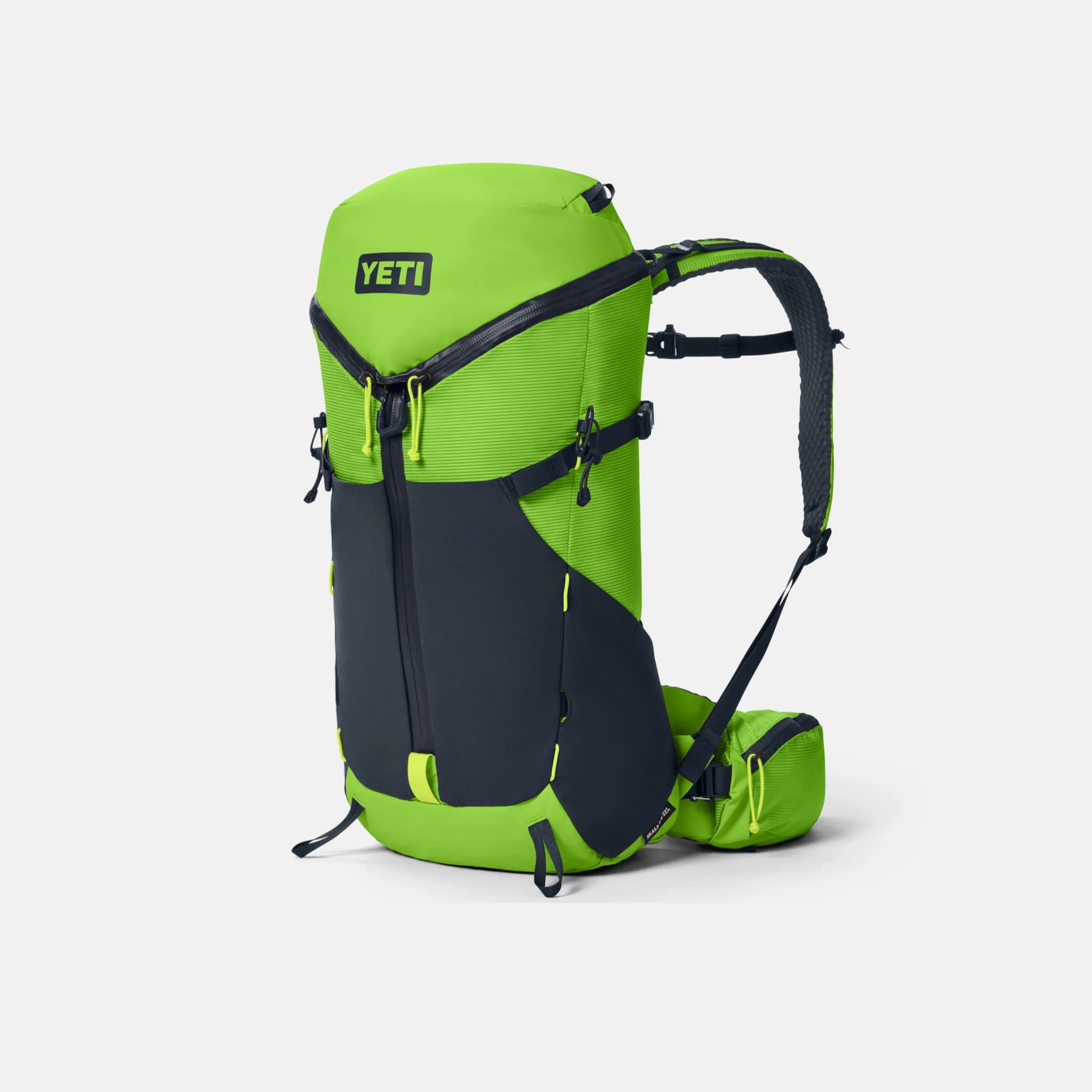 Bright green and black YETI backpack with padded shoulder straps and multiple zippers.