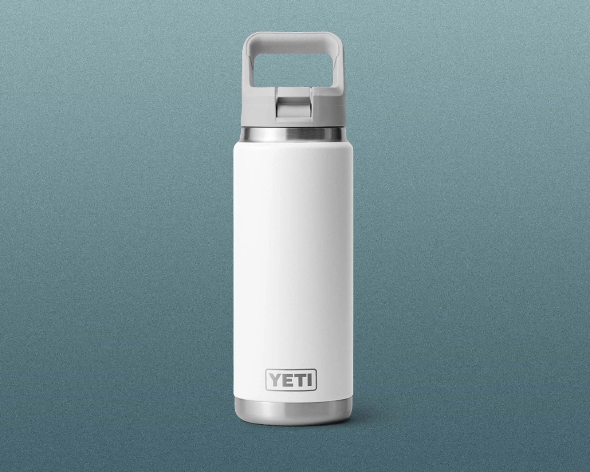 White YETI insulated water bottle with gray flip-top handle and stainless steel accents on a blue-gray background.
