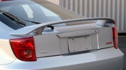 Silver Toyota Celica GTS rear with spoiler and red taillights in outdoor setting.