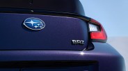Close-up of the rear of a dark blue Subaru BRZ showing the Subaru logo, BRZ badge, and right taillight.