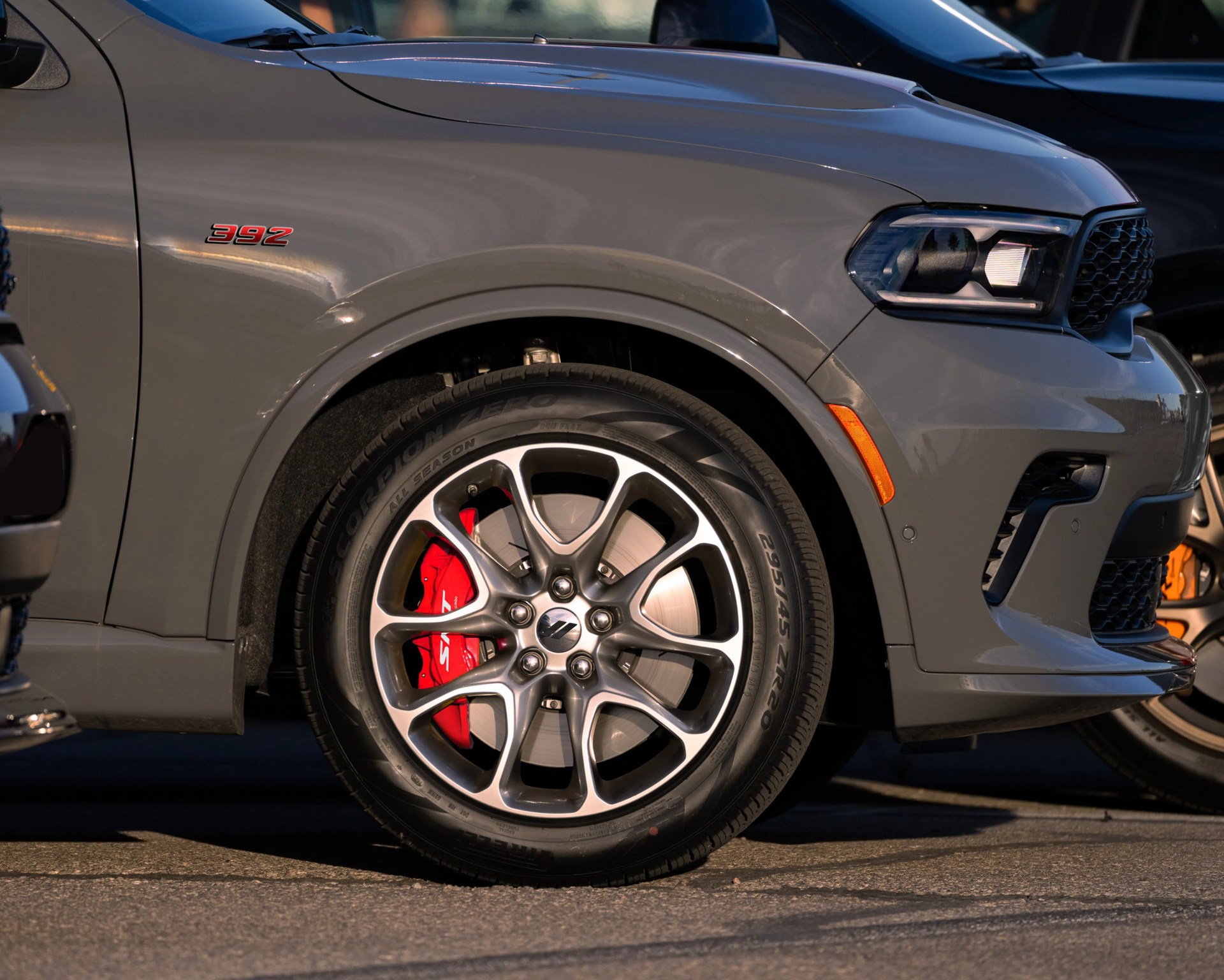 Gray SUV front wheel with red brake caliper and "392" badge on the fender.