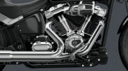 Close-up of a chrome V-twin motorcycle engine with visible exhaust pipes and part of the black frame.