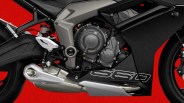 Close-up of a black and gray motorcycle engine and exhaust system with "660" decal on the fairing against a red background.