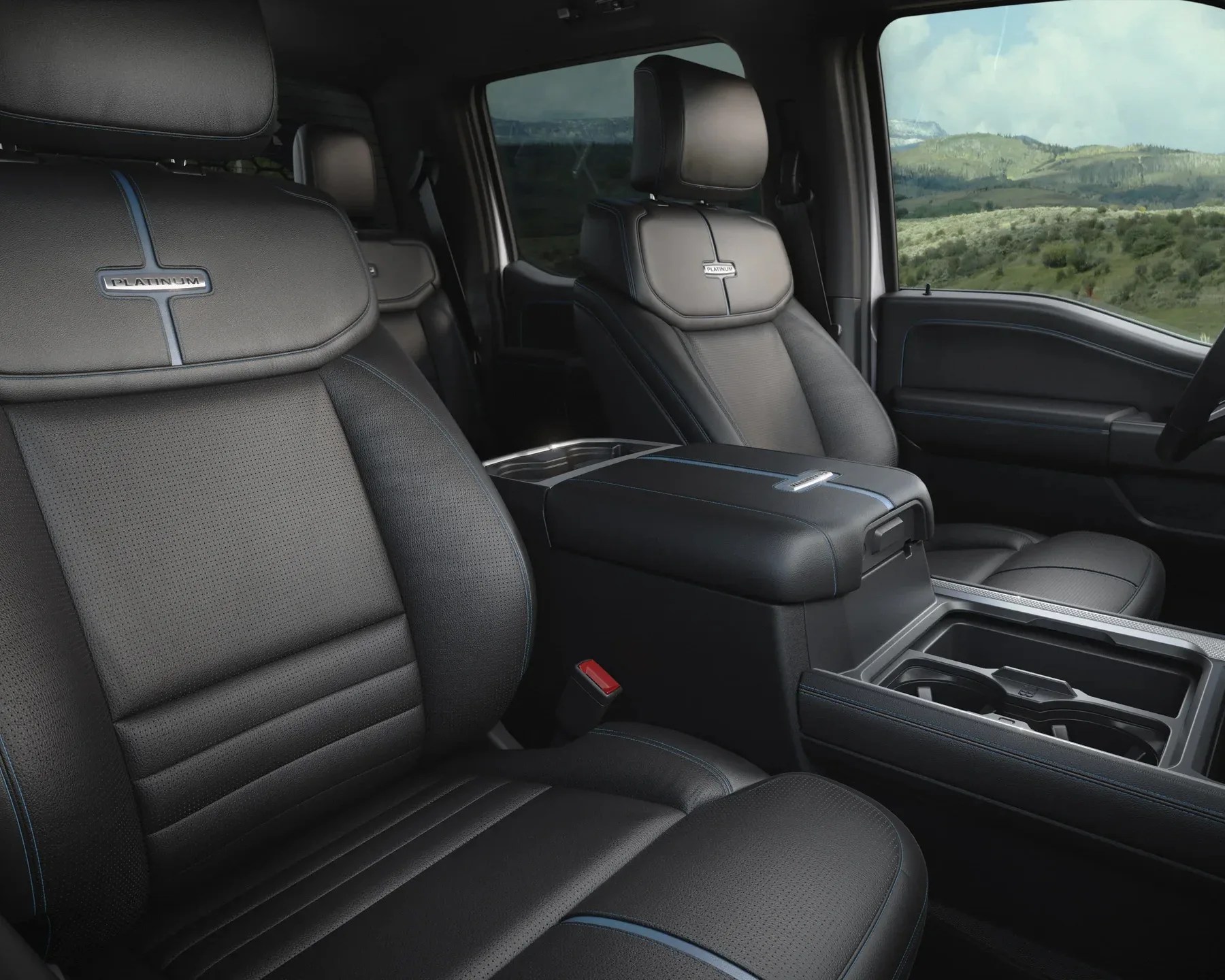 Black leather front seats with blue stitching and "Platinum" badges inside a vehicle cabin.