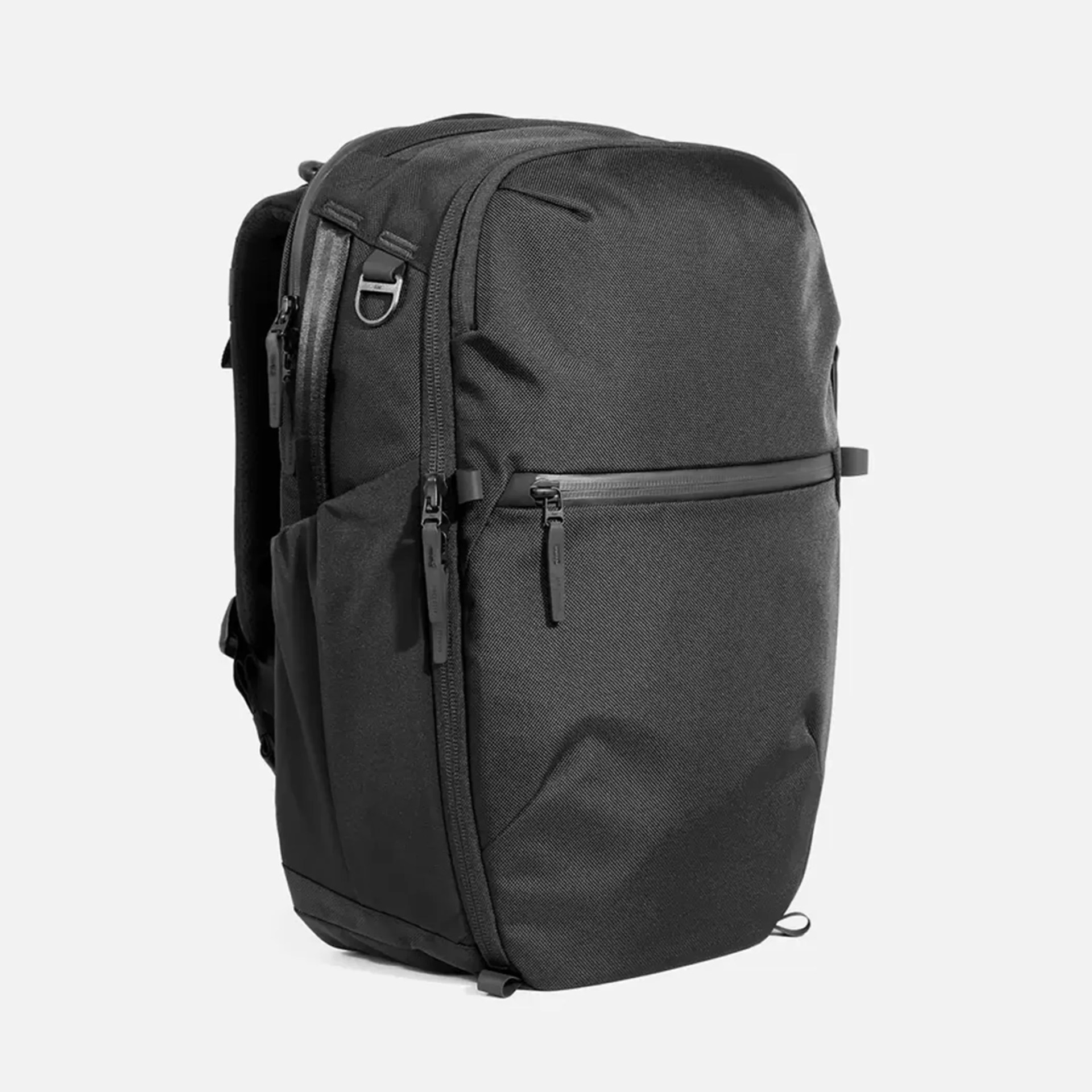 Black rectangular backpack with multiple zippered compartments and side pockets.