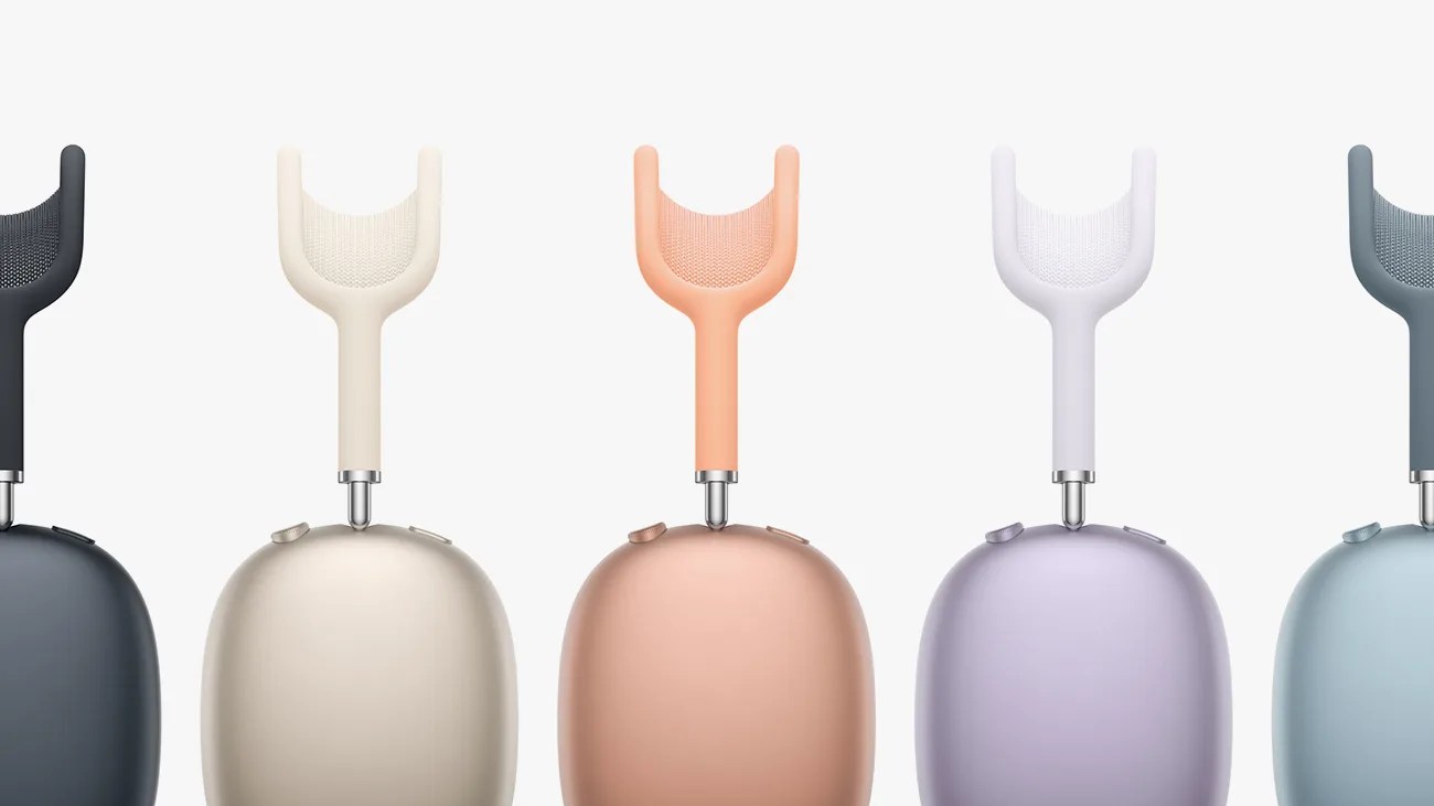 Five colorful electric scalp massagers with U-shaped silicone heads and rounded bases in black, cream, peach, lavender, and blue.