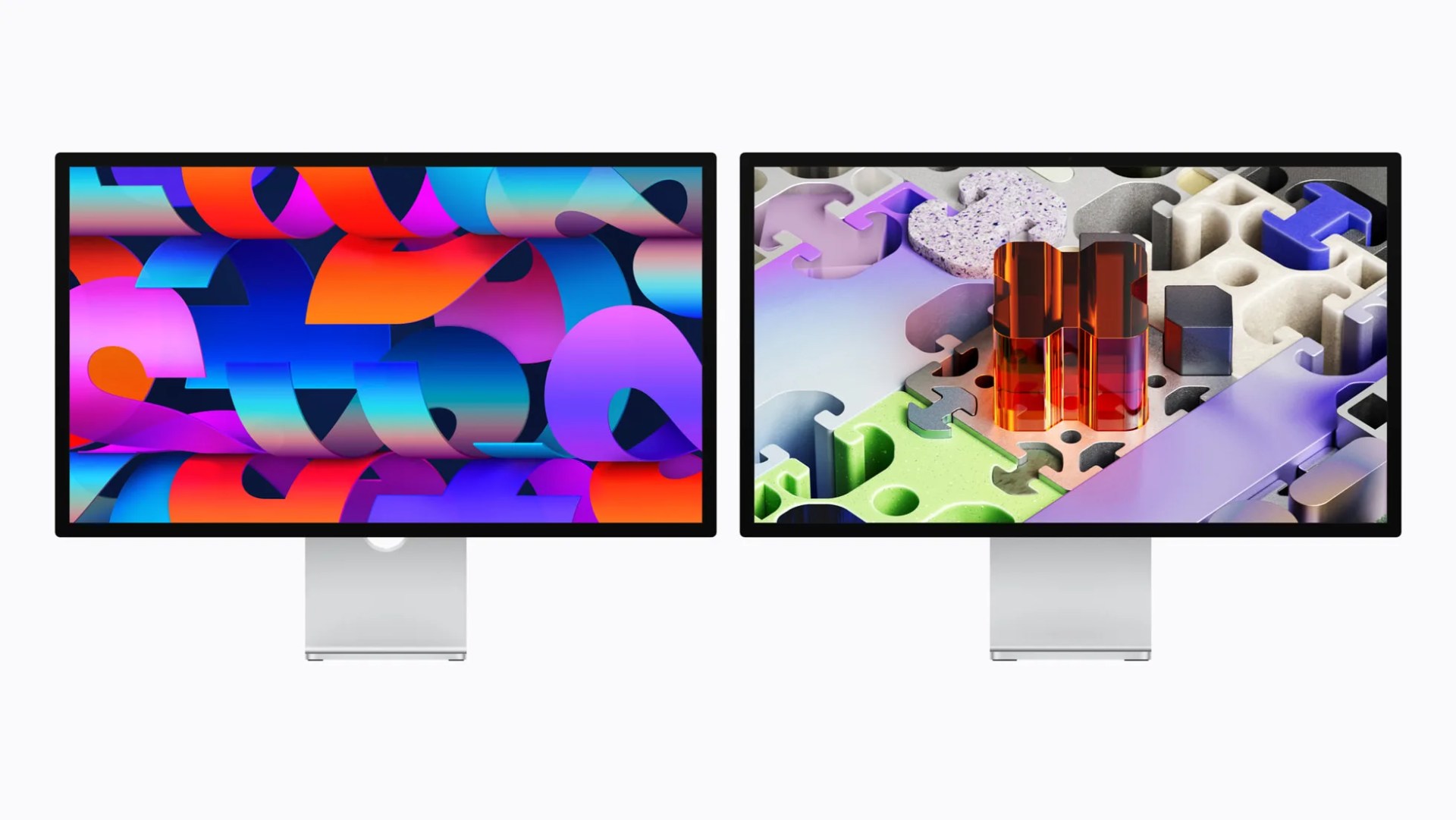 Two Apple Studio Displays side by side, each showing colorful abstract digital artwork on their screens.