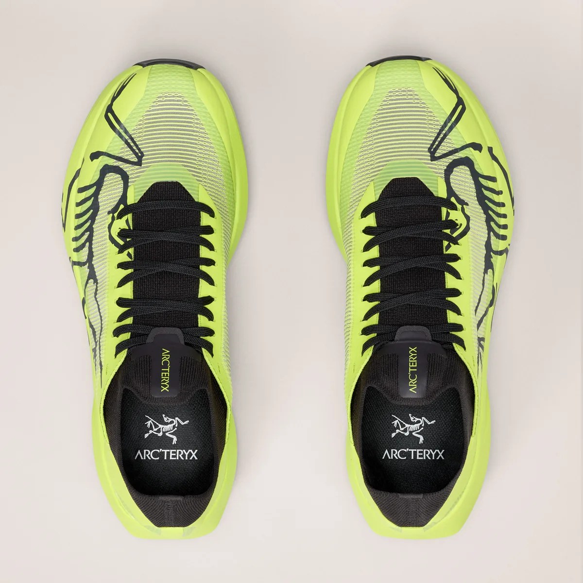 Pair of neon yellow and black Arc'teryx running shoes viewed from above on a light background.