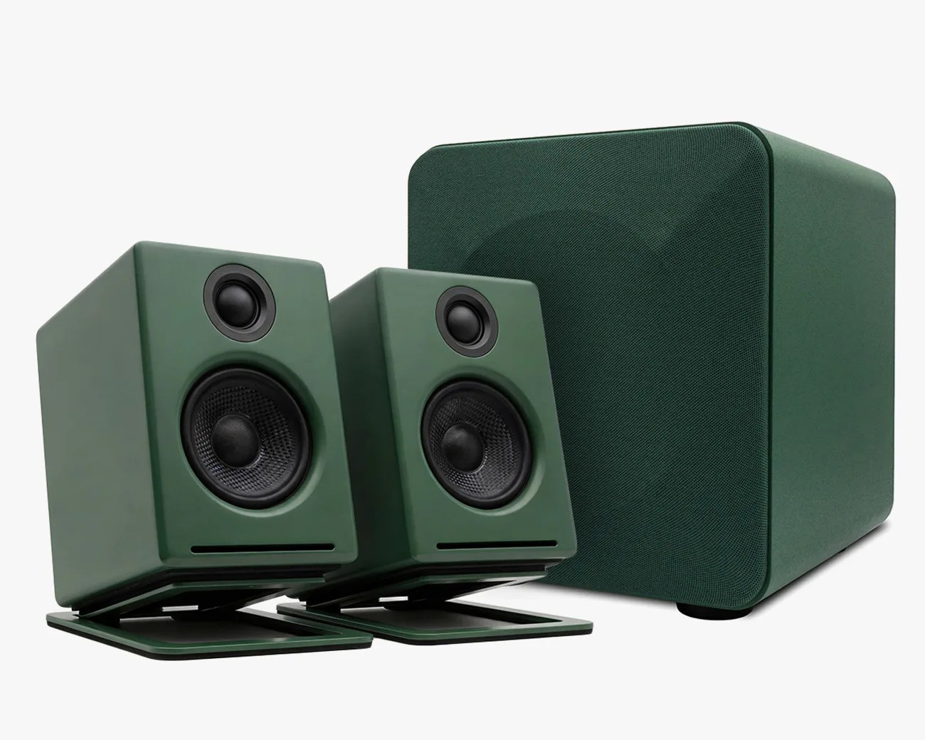 Green compact desktop speakers with black drivers and matching green subwoofer with fabric cover.