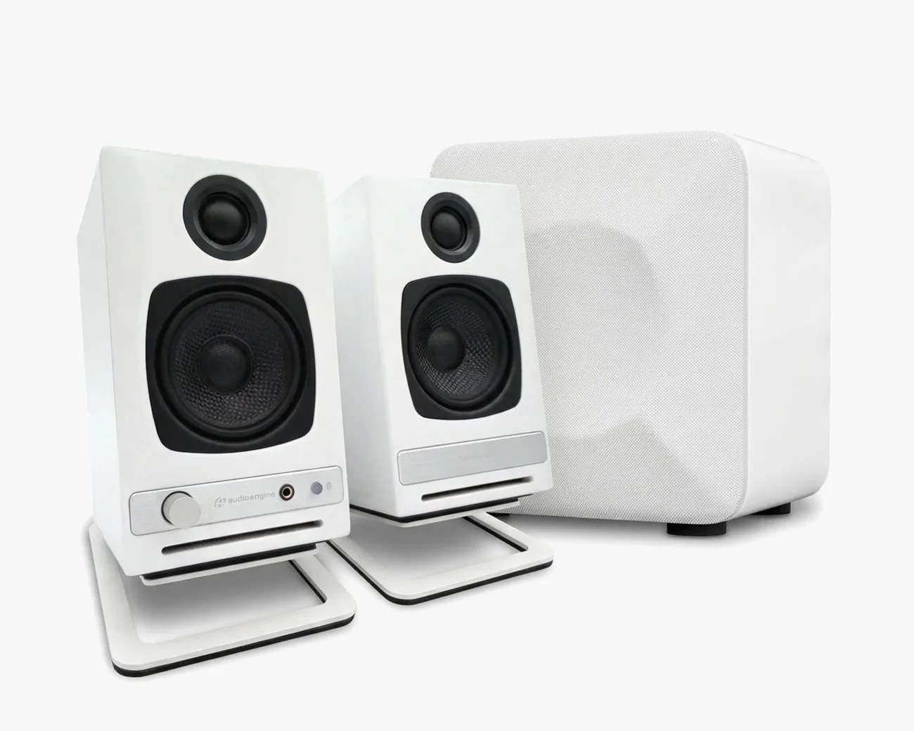 White desktop speaker set with two angled satellite speakers and a square subwoofer.