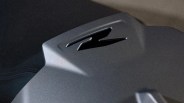 Close-up of a matte gray surface with a stylized "R" logo embossed on it.