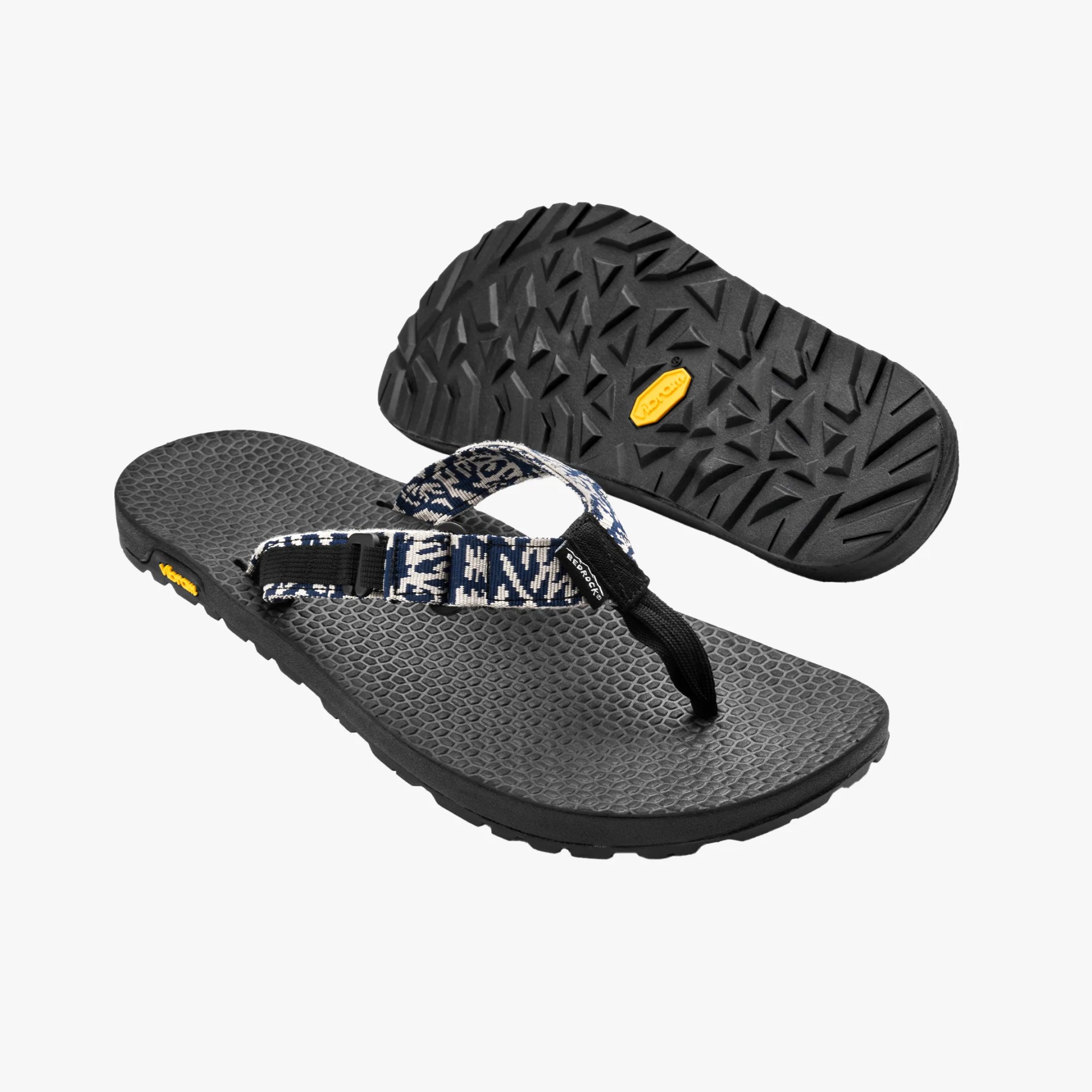 Pair of black flip-flops with textured footbeds and blue-and-white patterned fabric straps.