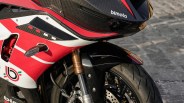 Close-up of a red, white, and black Bimota motorcycle front fairing and front wheel with carbon fiber details.