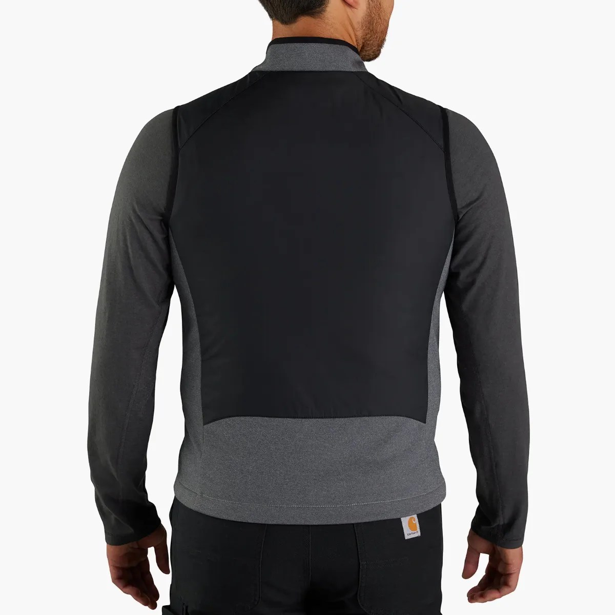 Back view of a man wearing a dark gray and black long-sleeve jacket with a black panel on the upper back.