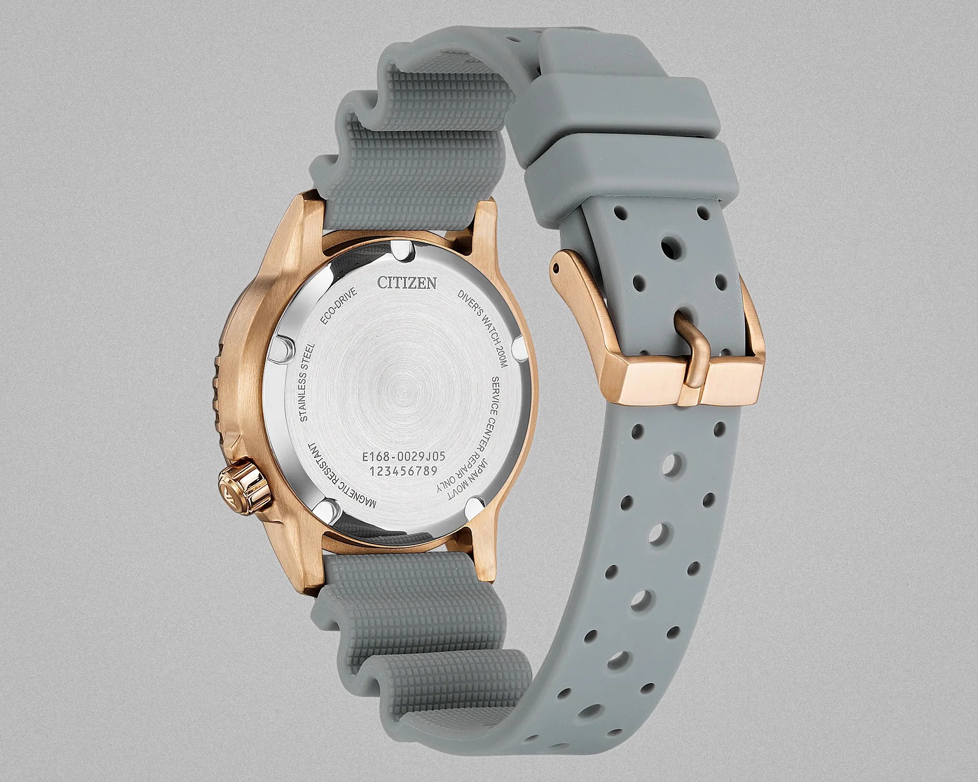 Back of a Citizen diver's watch with rose gold case and gray perforated rubber strap.